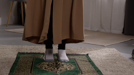 Muslimische-Frau-Mit-Hijab-Zu-Hause-Legt-Gebetsmatte-Auf-Etage-2